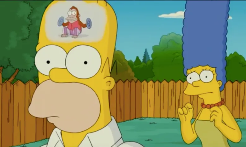 Homer Simpson z pustym spojrzeniem, w jego głowie małpka uderzająca w talerze, w tle zaniepokojona Marge