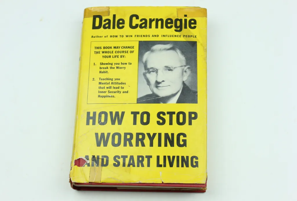 Stare wydanie książki Dale’a Carnegiego „How to Stop Worrying and Start Living” w żółtej obwolucie ze zdjęciem autora
